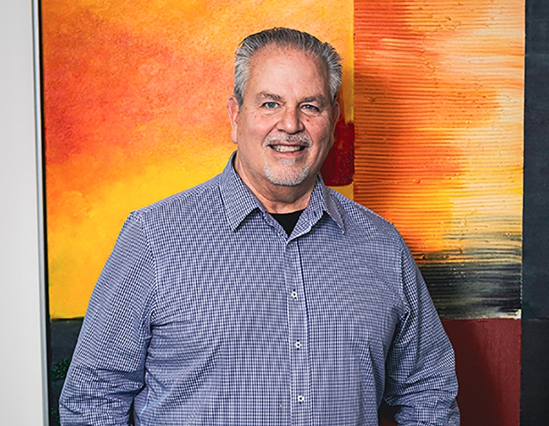 Man in front of an abstract painting in the PFREUNDT office, provider of mobile weighing systems.