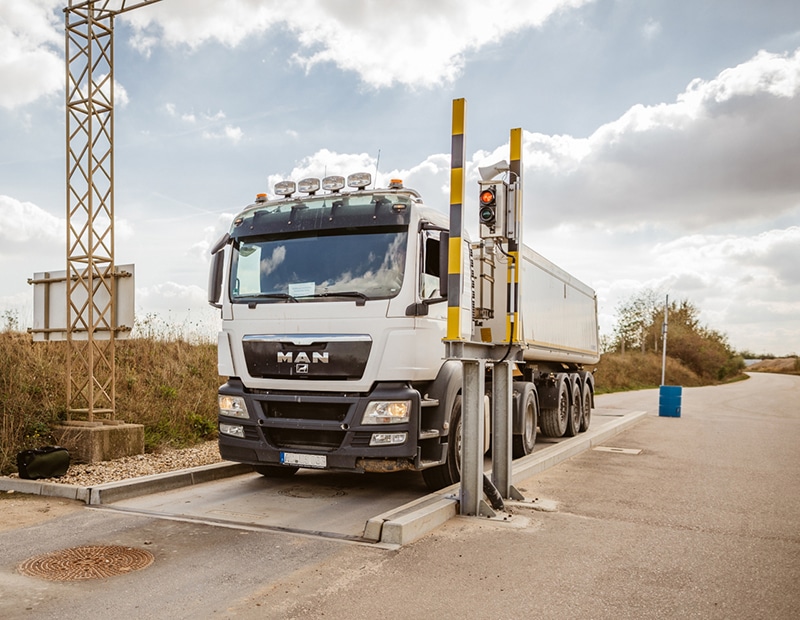 Truck on a PFREUNDT axle load scale outdoors, ideal for mobile weighing systems.