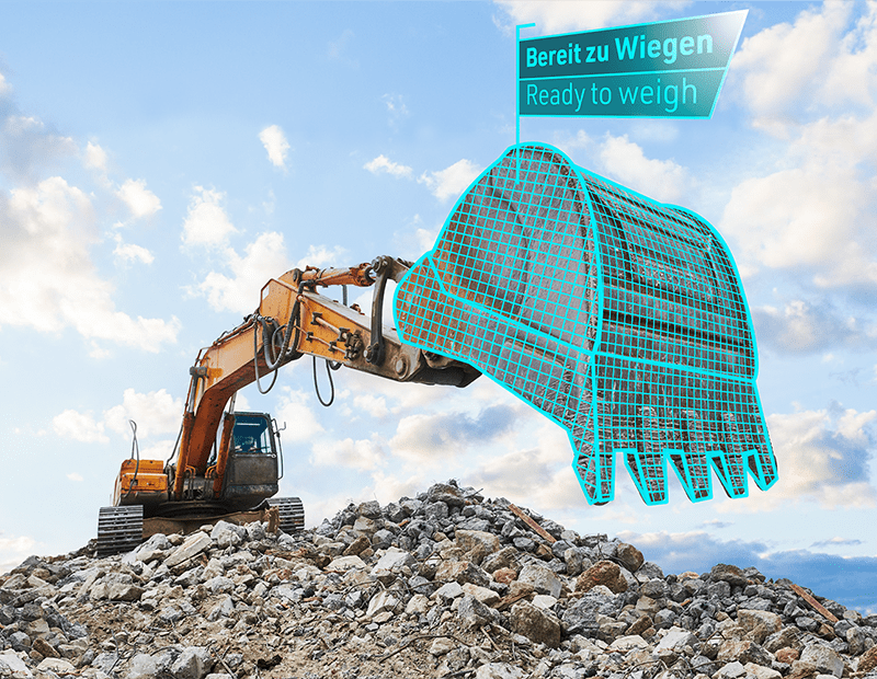 Excavator with PFREUNDT mobile weighing system on a pile of rocks, highlighted bucket, ready for weighing.