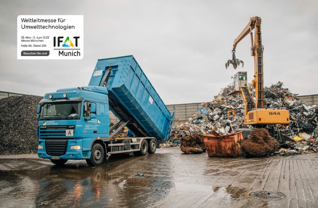 Truck tipping its load in front of an excavator at IFAT Munich, PFREUNDT presents mobile weighing systems for environmental technologies.