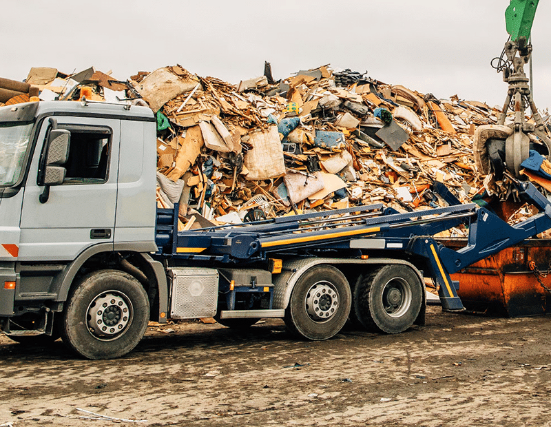 Skip loader with PFREUNDT skip loader scale in front of a scrapyard.