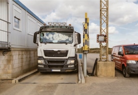 A lorry on the PFREUNDT weighbridge at an industrial site, surrounded by equipment for mobile weighing solutions.
