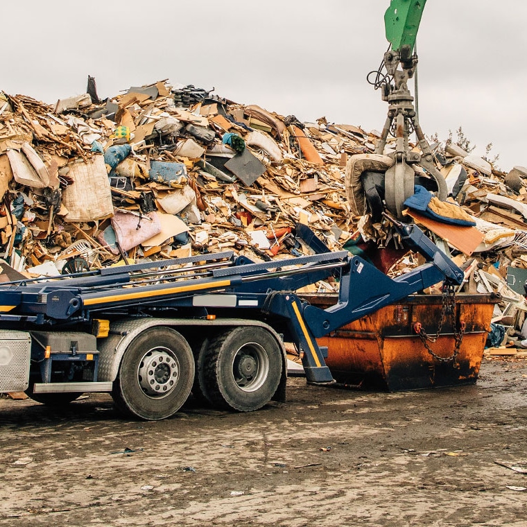 Skip loader with PFREUNDT Skip Loader Scale picking up a scrap container.
