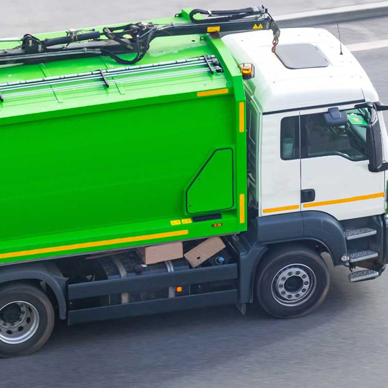Grünes Müllfahrzeug mit PFREUNDT Aufbauwaage im Einsatz.