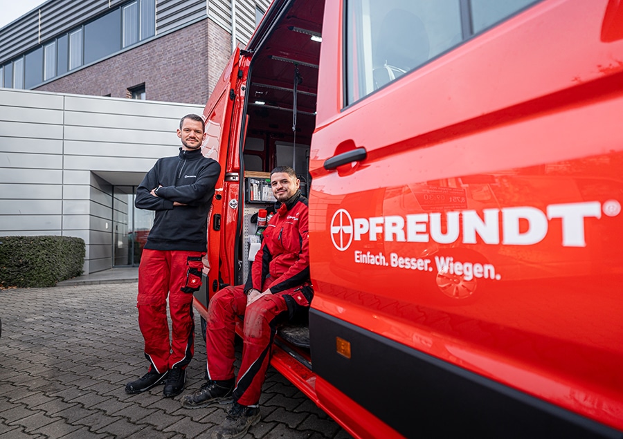 A PFREUNDT employee next to a service vehicle for mobile weighing systems.