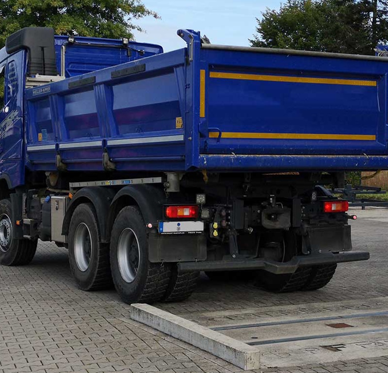 Blue dump truck during axle load measurement with the PFREUNDT Axle Load Scale.