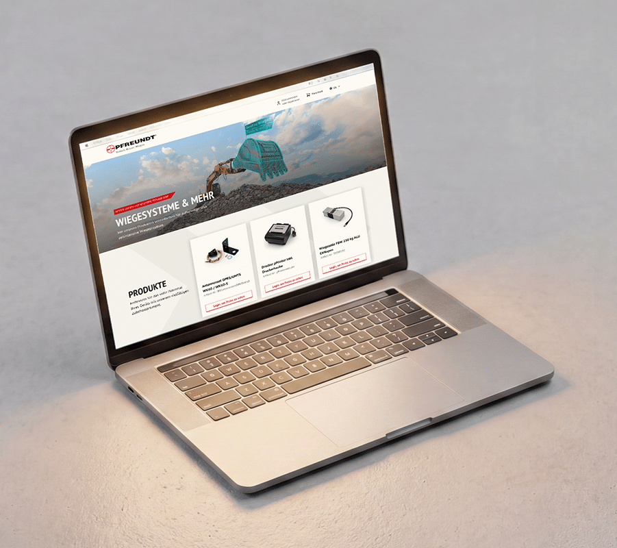 Auf einem Laptop, auf dem die PFREUNDT-Website geöffnet ist, sind mobile Wiegesysteme wie Baggerskalas, Bandwaagen und vieles mehr zu sehen.