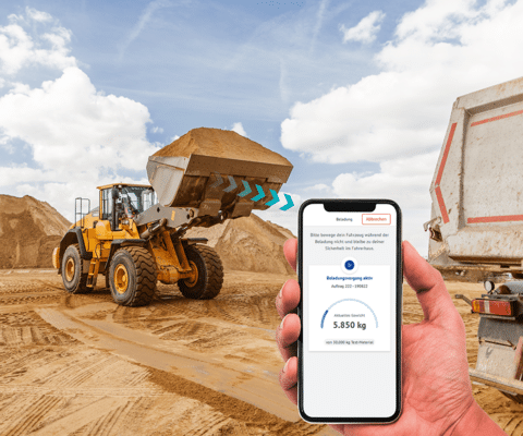 Mobile Wiegesysteme von PFREUNDT: Radlader und Smartphone-App zur präzisen Gewichtsmessung von Schüttgut auf einer Baustelle.