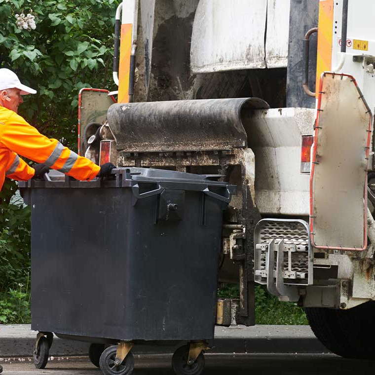 Waste collector pushing a bin to the lifter of a garbage collection vehicle with PFREUNDT Lifter Scale.
