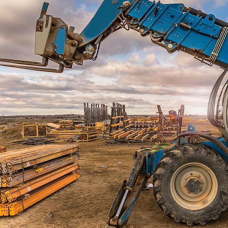 Blue telescopic handler with PFREUNDT Telescopic Handler Scale on a construction site.