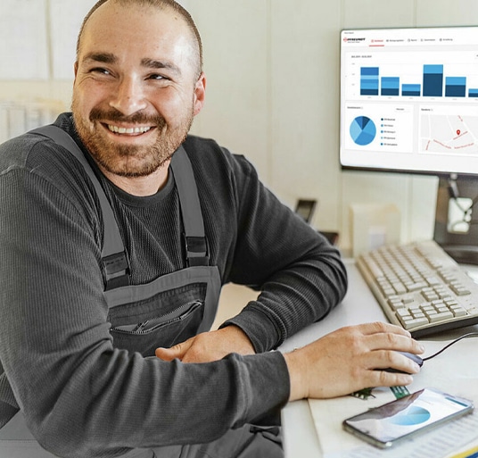 A PFREUNDT employee uses software for mobile weighing systems at a computer workstation in the office.